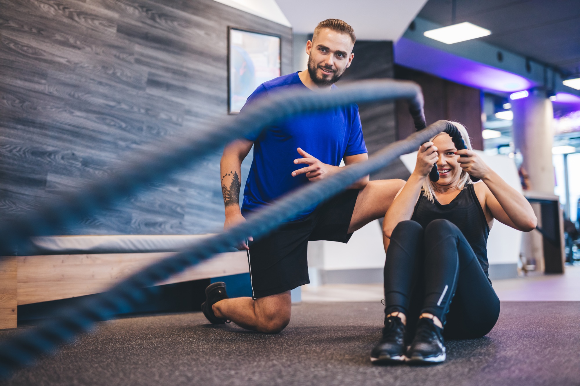 Young woman exercising with personal trainer at the gym.